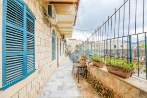 a balcony with blue shutters and a table and chairs at Mendis accommodation in Safed