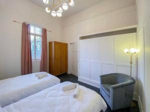 - une chambre avec deux lits, une chaise et un miroir dans l'établissement Mendis accommodation, à Safed