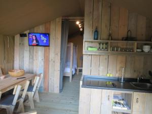 a kitchen with wooden walls and a table and a sink at DOMAINE DU SIESTOU WINE RESORT & spa in Laure-Minervois