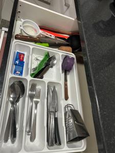 a tray with silver utensils on a counter at Apartamento Mobiliado em Limeira in Limeira