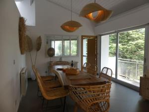 a dining room with a wooden table and chairs at VILLATIMAHE 4 étoiles vue montagnes au calme 6 min des plages in Urrugne