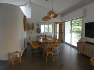 a dining room with a table and chairs and a television at VILLATIMAHE 4 étoiles vue montagnes au calme 6 min des plages in Urrugne