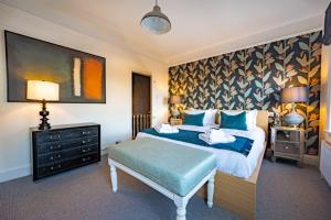una camera da letto con un grande letto con una coperta blu di No33 Number 5 BOUTIQUE COTTAGE a Hunstanton
