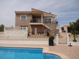 a villa with a swimming pool in front of a house at LAS PALOMAS, appartement 3 chambres avec piscine in Turís