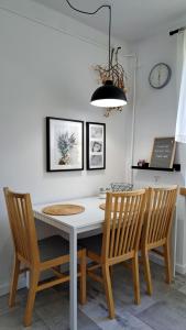 a dining room with a white table and chairs at Apartament Między Jeziorami in Augustów