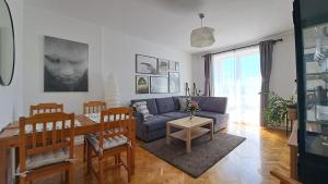 Una sala de estar con un sofá azul y una mesa. en Apartament Między Jeziorami, en Augustów