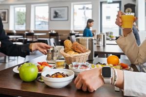 un gruppo di persone seduti a un tavolo con cibo di Hotel Adler a Friedrichshafen