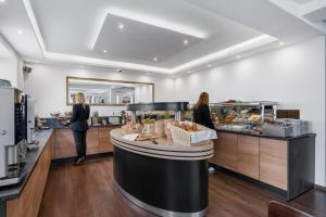 two women standing at a counter in a bakery at Hotel Adler in Friedrichshafen