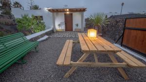 a wooden picnic table with a lamp on a patio at Casa Ico Lanzarote in Tías