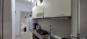 a kitchen with a sink and a refrigerator at Wave Sound Apartments - Beach View in Skala Marion