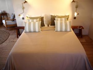 a large white bed with four pillows in a room at Casa Amandava in Salobreña