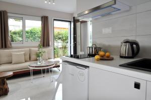 una cucina e un soggiorno con divano e tavolo di Alekos Luxury Suites Free 24h Transportation From - To Airport a Artemida