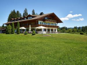 ein großes Haus auf einem grünen Feld in der Unterkunft Landhotel zur Grenze in Isny im Allgäu