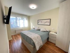 a bedroom with a large bed and a window at Piso recién reformado en Gascona in Oviedo