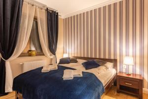 a bedroom with a bed with blue sheets and curtains at Comfort Studio Stone Hill in Szklarska Poręba
