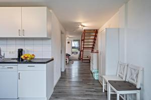 a kitchen with white cabinets and a table and chairs at Zeiser in Pfullendorf