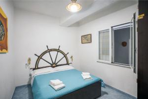 a bedroom with a blue bed and a window at Casa Gloria in Positano +12 photos