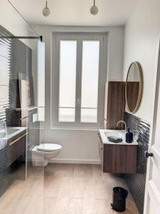 een badkamer met een toilet, een wastafel en een spiegel bij Le Maurice 4 - Villa Maurice in Compiègne