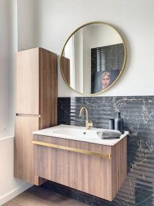een badkamer met een wastafel en een spiegel bij Le Maurice 4 - Villa Maurice in Compiègne
