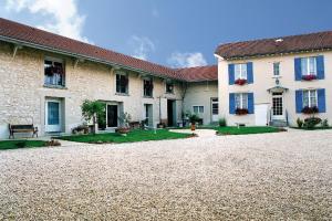 a house with a gravel driveway in front of it at Les chambres d'hôtes Joy in Val de Vesle