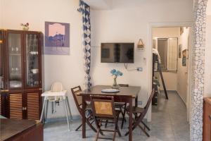 a dining room with a table and chairs and a television at Casa Gloria in Positano