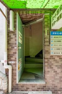 an entrance to a building with a green door at さくらイン駅前癒やし空間 in Tokyo