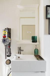 a white bathroom with a sink and a mirror at さくらイン駅前癒やし空間 in Tokyo