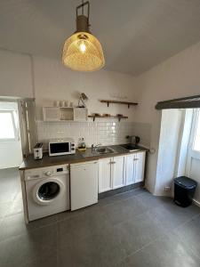 uma cozinha com um lavatório e uma máquina de lavar roupa em Apartment in old town with roof terrace and fibre, Tarifa em Tarifa