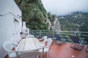 a table and chairs on a balcony with a view at Casa Gloria in Positano