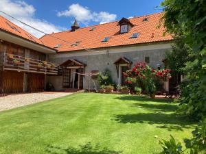 ein Haus mit einem Garten mit grünem Gras in der Unterkunft Pension u Sv. Prokopa in Středokluky