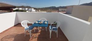 d'une table bleue et de deux chaises sur un balcon. dans l'établissement Esparto y sal, à El Pozo de los Frailes
