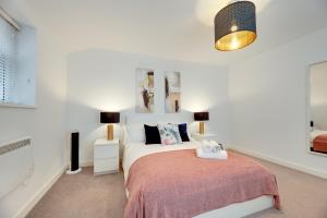 a white bedroom with a bed and two lamps at Charltons Bonds Apartments 22 by Week2Week in Newcastle upon Tyne