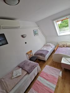 2 łóżka w pokoju z białymi ścianami w obiekcie Landhaus Forrás w Balatonfüred +10 zdjęć