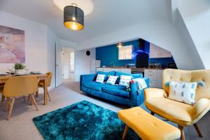 a living room with a blue couch and a table at Charltons Bonds Apartments 22 by Week2Week in Newcastle upon Tyne