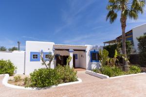 a white house with a palm tree in front of it at Villa Miguel in Sant Rafael de Sa Creu