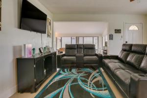 a living room with a couch and a flat screen tv at Margate Home with Hot Tub and Putting Green! in Margate