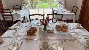 Lurgan House في ويستبورت: طاولة عليها قماش الطاولة البيضاء مع الطعام