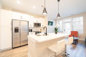 a kitchen with white cabinets and a large white counter top at Atlanta’s Summerhill Stay in Atlanta