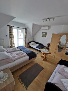 a large bedroom with two beds and a table at Landhaus Forrás in Balatonfüred