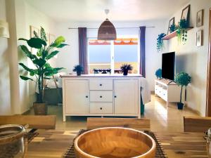 a living room with a white dresser and a large window at Los Geraneos in Águilas