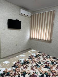 1 dormitorio con 1 cama y TV en la pared en Suhin Dol Hotel en Belimel
