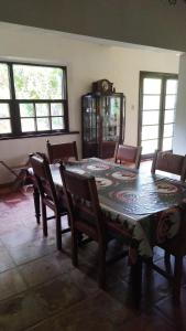 a dining room with a table and chairs and a clock at Sitio três porteiras in Paty do Alferes