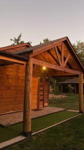 a wooden pavilion with a roof on a lawn at ENTRE BAMBUES in Los Ángeles