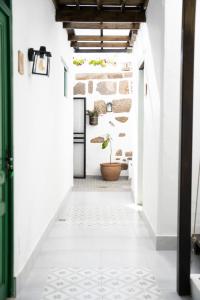 un corridoio con pareti bianche e una pianta in un vaso di Casa El Terrero a Gáldar