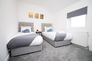 una camera da letto con due letti e una finestra di 3-Bed Afan Valley House - Free Parking a Glyncorrwg