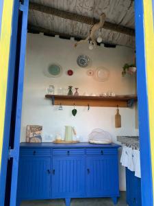 un armario azul con placas en la pared en Chalé Perto Do Céu, en São Thomé das Letras