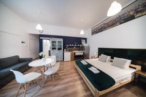 Roller Aparthotel في كراكوف: غرفة نوم بسرير وطاولة وكراسي