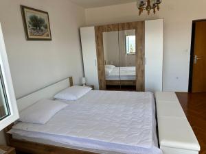 - une chambre avec un lit blanc et un miroir dans l'établissement Spacious 2-room apartment with beautiful sea view, à Crikvenica