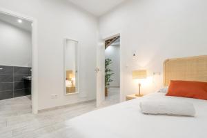 a white bedroom with a large bed and a bathroom at GAV Cerrillo in Ronda