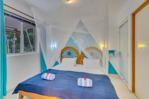 a bedroom with a blue and white bed with two pillows at Tropical Divers Resort in Kralendijk
